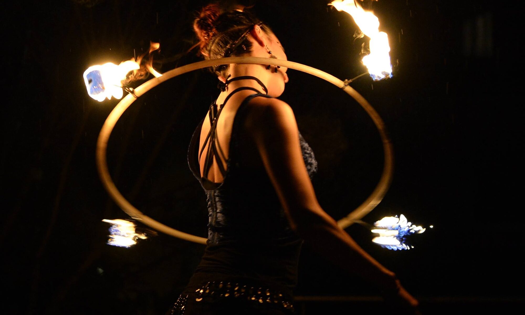 A firehoop spinning arund the neck of Christiane Meyer (Miigaa)